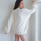 OKAKIE cream oversized mock-neck tunic sweater with dropped shoulders and ribbed cuffs worn by a model from behind