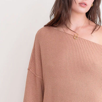 OKAKIE cream heavy ribbed knit tunic sweater with a wide neckline and dropped shoulders worn off the shoulder