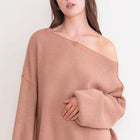 OKAKIE cream oversized ribbed knit tunic sweater with dropped shoulders and a wide neckline worn off the shoulder