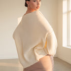 OKAKIE cream heavy ribbed knit tunic sweater with boat neckline and drop shoulders worn by a model