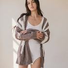 Model wearing an OKAKIE dusty grape two-tone marled cotton cardigan with drop shoulders and wide sleeves.