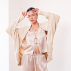 OKAKIE ÉVANE silky modal cocoon cardigan in beige with an oversized draped fit and open front design on a model.