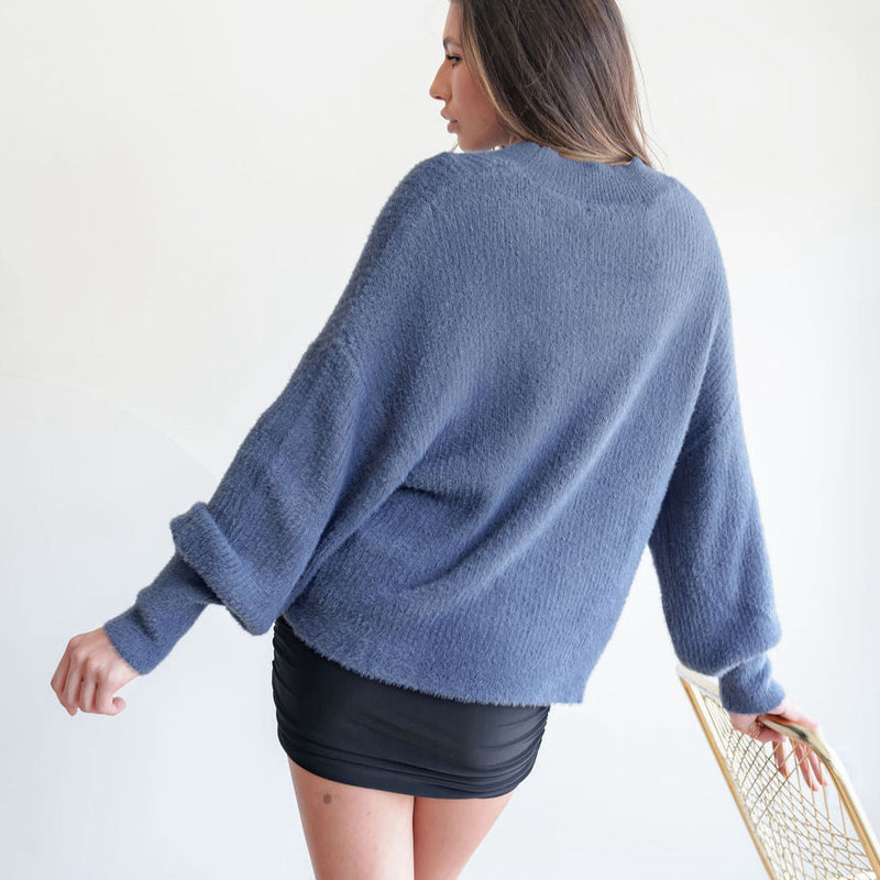 OKAKIE fuzzy mock-neck tunic in blue with voluminous sleeves and dropped shoulders, worn by a model from behind.