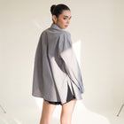 OKAKIE grey cotton poplin boyfriend over-shirt with side slits and high-low hem worn by a model