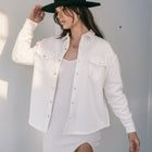 OKAKIE ivory cotton snap shacket with silver buttons, oversized fit, and chest pockets worn over a matching dress.