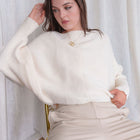 OKAKIE ivory knit sweater with a relaxed silhouette, drop shoulders, and wide sleeves worn by a model