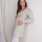 Model wearing an OKAKIE light grey wrap cardigan with bishop sleeves, patch pockets, and a self-tie waist belt.