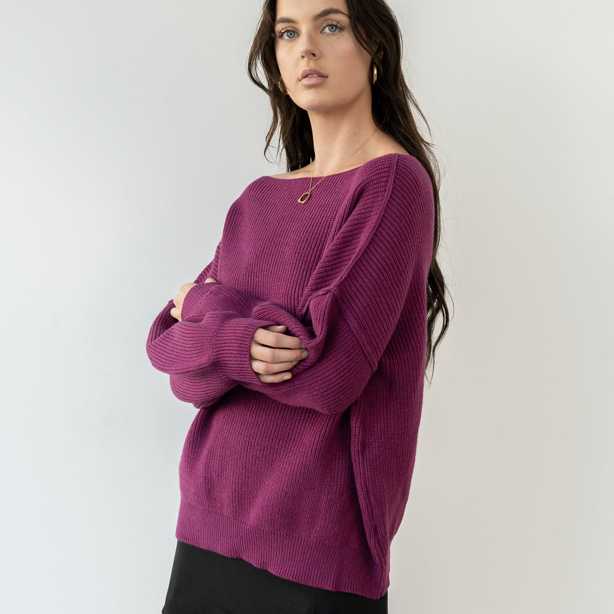 Model wearing an OKAKIE magenta heavyweight tunic sweater with a wide neckline and textured knit in a relaxed fit.