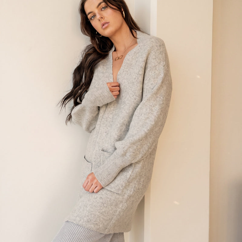 Model wearing OKAKIE Marcelle heavy knit coatigan in light grey with oversized pockets and ribbed cuffs