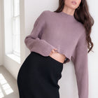 OKAKIE mauve crop ribbed sweater with a high neckline and long sleeves worn by a model in a bright studio setting.