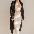 OKAKIE oversized black purl knit coatigan with wide sleeves and patch pockets worn over a cream lounge set