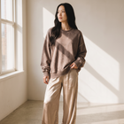 Model wearing OKAKIE oversized brown vintage wash fleece pullover with balloon sleeves and ribbed trim.