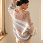 OKAKIE oversized pastel striped V-neck knitted sweater tunic worn by a woman with a bun, back view.