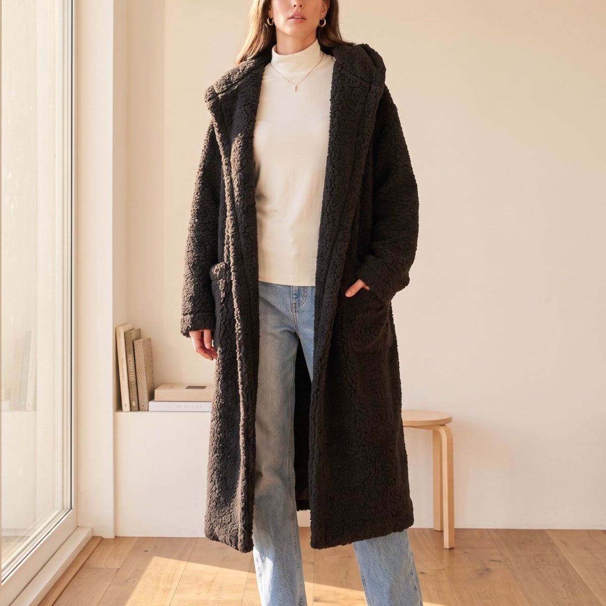 Model wearing an OKAKIE dark brown plush teddy maxi robe coat with a shawl collar and side pockets in a bright room.