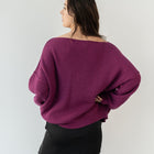 OKAKIE magenta heavy tunic knit sweater with a wide neckline and relaxed drop shoulders, back view on a model.