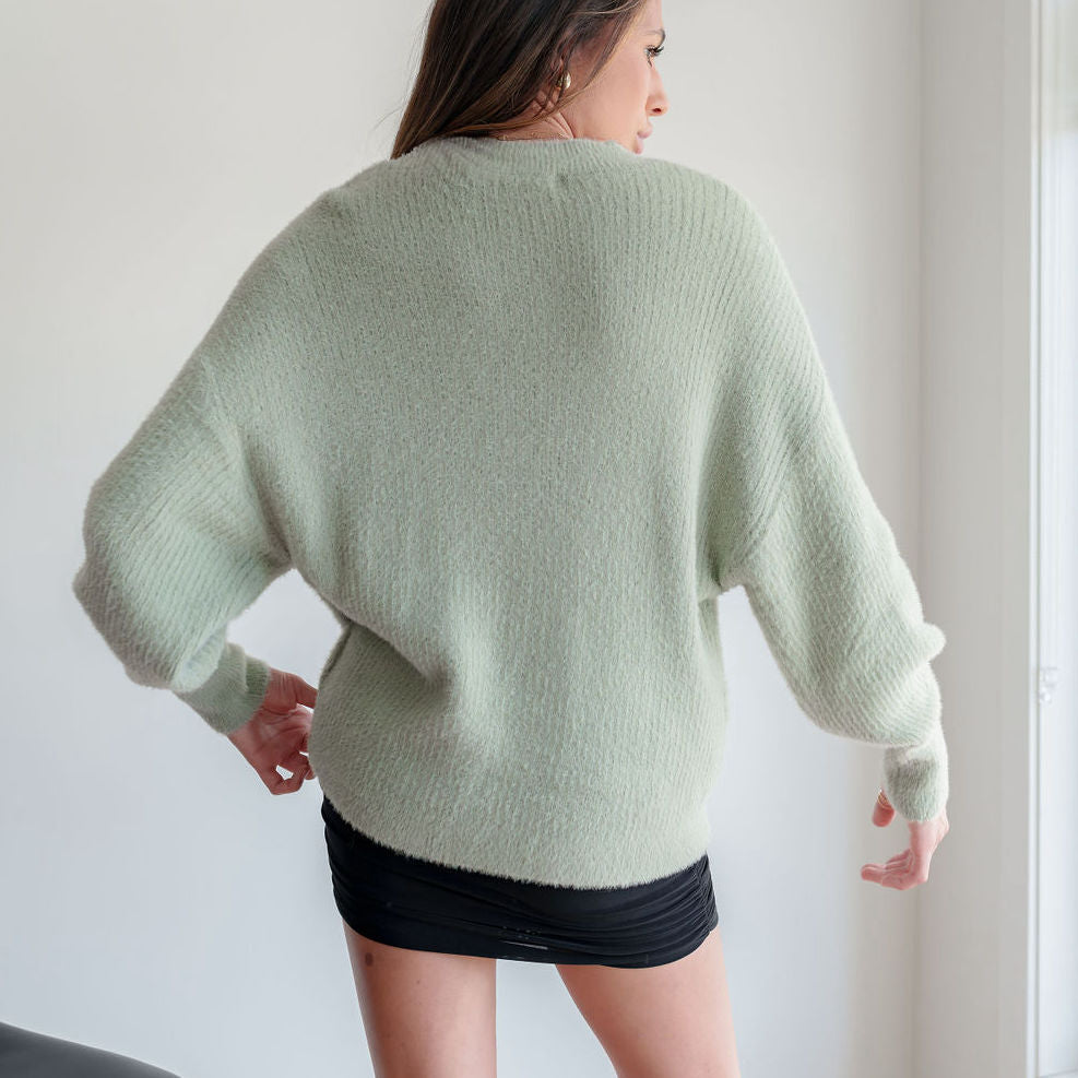 OKAKIE sage green fuzzy mock-neck tunic sweater with drop shoulders and long sleeves worn by a model, back view