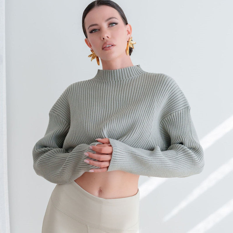 OKAKIE Elodie cropped sweater in sage green heavy ribbed knit with high neck and drop shoulders worn by a model