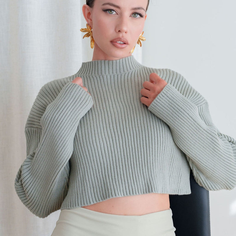 Model wearing OKAKIE sage green heavy ribbed knit cropped sweater with a high neckline and relaxed drop shoulders.