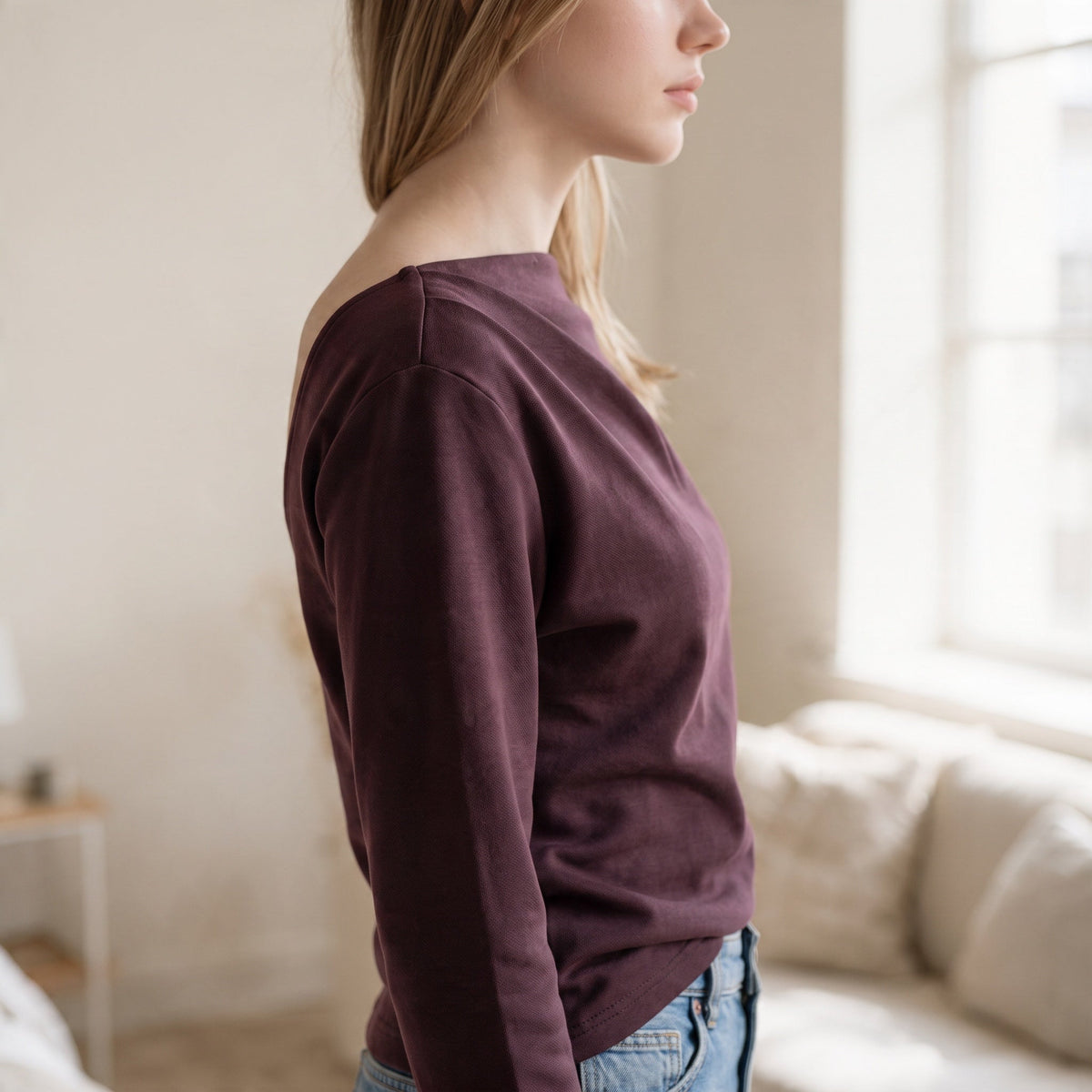 OKAKIE Solène asymmetric scuba knit top in deep plum with long sleeves and a sculptural neckline on a model
