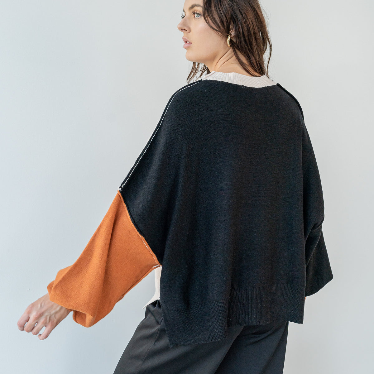 OKAKIE Solène three-tone knit sweater with cream, charcoal, and rust colour-block sleeves and a relaxed drop-shoulder.