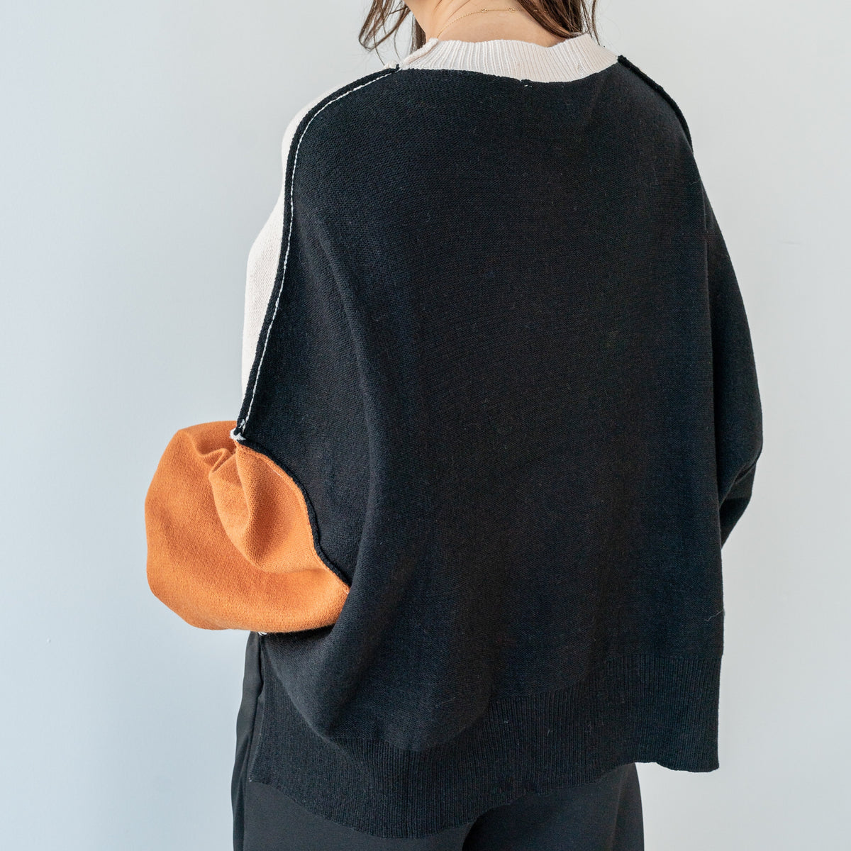 OKAKIE Solène three-tone knit sweater featuring cream, charcoal, and rust colour-block sleeves and a relaxed fit.