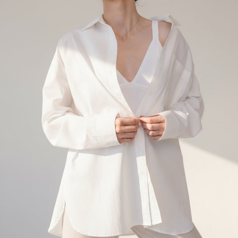 OKAKIE white cotton poplin boyfriend overshirt with a relaxed oversized fit, pointed collar, and button-front closure.