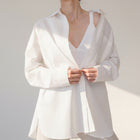 OKAKIE white cotton poplin boyfriend over-shirt with a tailored collar and button-up front worn over a white tank top